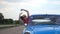 Young couple traveling on vintage car at country road in summer time. Attractive woman leaning out from window of moving