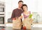 Young Couple Unpacking Shopping In Modern Kitchen