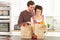 Young Couple Unpacking Shopping In Modern Kitchen