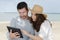 Young couple using digital tablet at seaside town