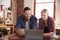 Young couple using a laptop in kitchen, close up, front view