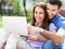 Young couple using laptop outdoors