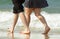 Young couple on vacation walking along waters edge of ocean