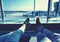 Young couple waiting for the plane at an airport. humans legs with the plane on the background