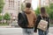 Young couple waiting to cross street, back view. Traffic rules