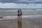 Young couple walk along the wet beach holding hands on a stormy day in Bryron Bay NSW Australia 8 29 2014