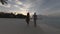 Young couple are walking on the beach during sunset