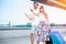 Young couple walking in front of an airport terminal building, pulling suitcases