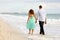 Young couple walking hand in hand on the beach thi