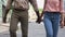 Young couple walking holding hands, newlyweds vacation, active leisure, tourism