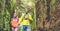 Young couple walking inside rainy forest - Hiker people having fun in to the woods - Travel, discovery, trekking, vacation and