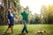 Young couple walking in park with dog holding hands.wife with husband walking outdoor with dog