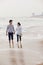 Young couple walking by the waters edge on the beach, China