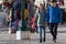 Young couple walks along a clothing store on the central promenade of Riva degli Schiavoni in a winter sunny day.