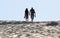 Young couple walks on sand dune. Fingal Bay. Port Stephens. Australia.