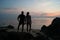 Young couple watch a decline, the Guy with the girl stand on the seashore and look in a distance.