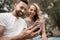 Young couple watches a video on a smartphone sitting on a Park b