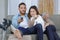 Young couple watching tv on sofa at home