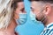 Young couple wearing protective face mask while staring on each other`s  eyes - Love and relationship during coronavirus time -