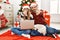 Young couple of wife and husband wearing christmas hat using laptop pointing with finger to the camera and to you, confident