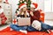 Young couple of wife and husband wearing christmas hat using laptop serious face thinking about question with hand on chin,
