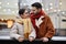 Young couple in winter date at ice skating rink and looking at each other with love