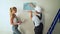 Young couple workers at construction site glues wallpaper to the wall