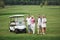 Young couples getting ready to play. A group of smiling friends came to the hole on a golf cart