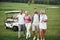 Young couples getting ready to play. A group of smiling friends came to the hole on a golf cart