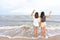 Young couples prefer Asian women who are tourists. walking along the beach which the waves crashed with a cheerful expression on