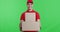 Young courier in red uniform bringing parcels to camera