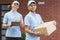 Young couriers with package and clipboard
