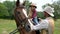 A young cowboy and his sweet daughter on horseback