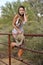 Young Cowgirl Climbing Fence