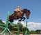 Young cowgirl jumping with chestnut horse