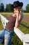 Young cowgirl sitting on a fence