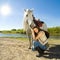 Young cowgirl with white horse outdoor