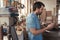 Young craftsmen using a tablet in his woodworking workshop