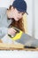 Young craftswoman cutting wooden board with handsaw