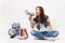 Young crazy casual woman student in denim clothes screaming holding megaphone sitting near globe backpack school book