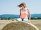 Young crazy caucasian woman sits on the stack of straw and throw