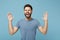 Young crazy wild man in casual clothes posing isolated on blue wall background, studio portrait. People lifestyle