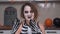 Young crazy woman with creepy makeup and skeleton costume plays and grimaces at the camera. Actress staged performance
