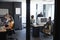 Young creative team working together at computers in a casual office, seen through glass wall