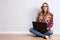 Young creative woman sitting in the floor with laptop./ Casual b