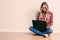 Young creative woman sitting in the floor with laptop./ Casual b