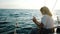 Young curly girl sailing yacht and using a smartphone shows a view