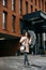 Young curly mestizo woman under umbrella walking the street