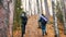 Young curly woman and a boy on scandinavian walk in the forest. Going uphill.