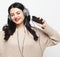 Young curvy brunette woman in headphones listening to music